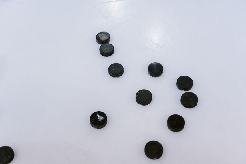 Pucks de hóquei espalhados sobre uma superfície de gelo.